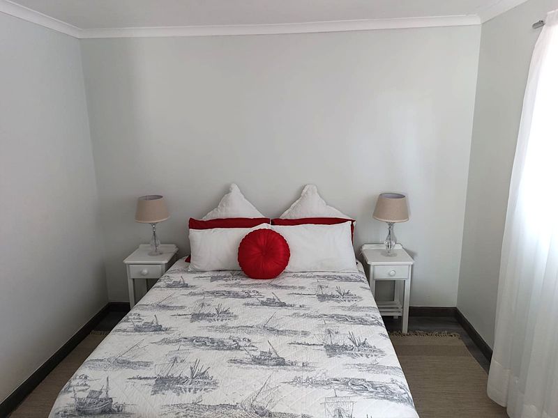 A well-maintained bedroom featuring neutral wall tones, cove cornicing, and dark skirting boards, providing a clean and simple foundation for personal styling.