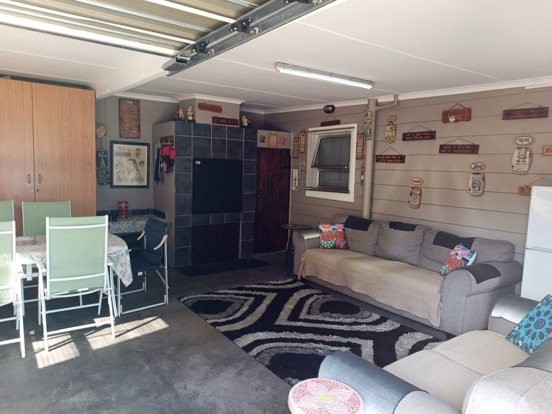 A converted garage space currently utilized as a living area, featuring a built-in fireplace, overhead lighting, and integrated storage cabinetry.