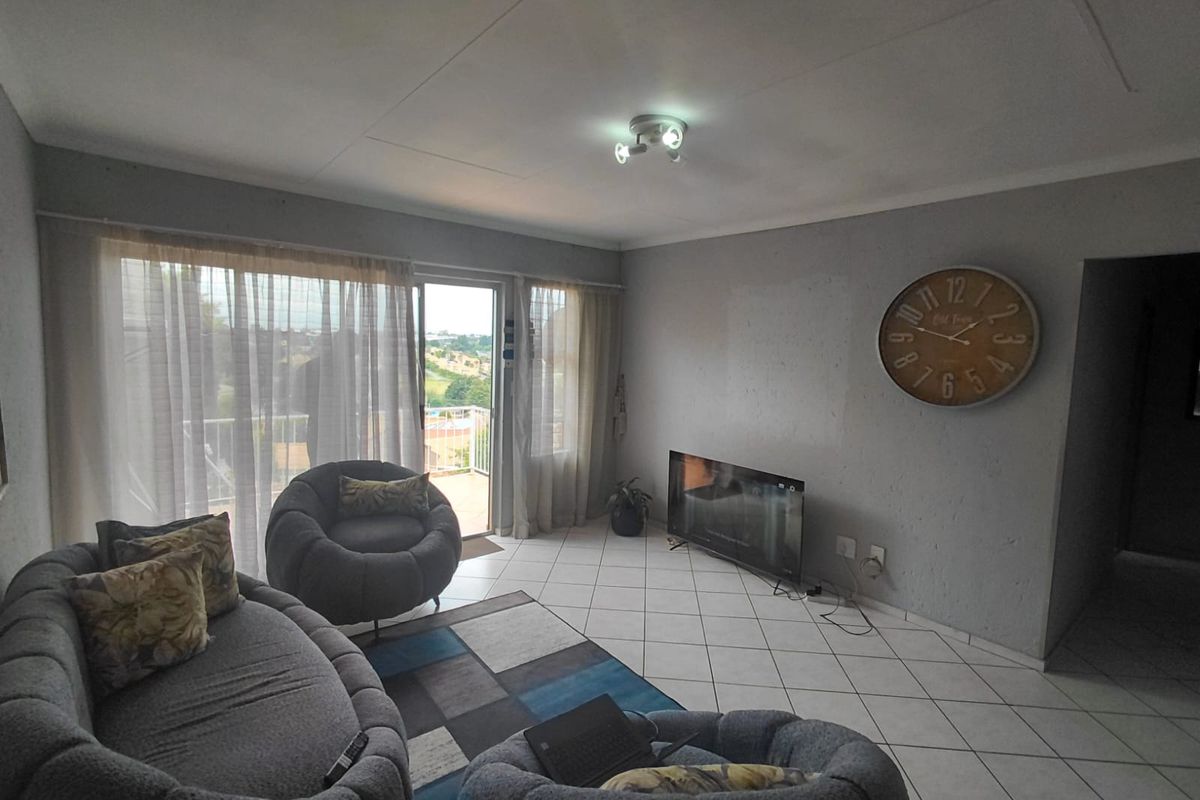 Living room featuring tiled flooring and a sliding glass door providing access to an outdoor balcony area.