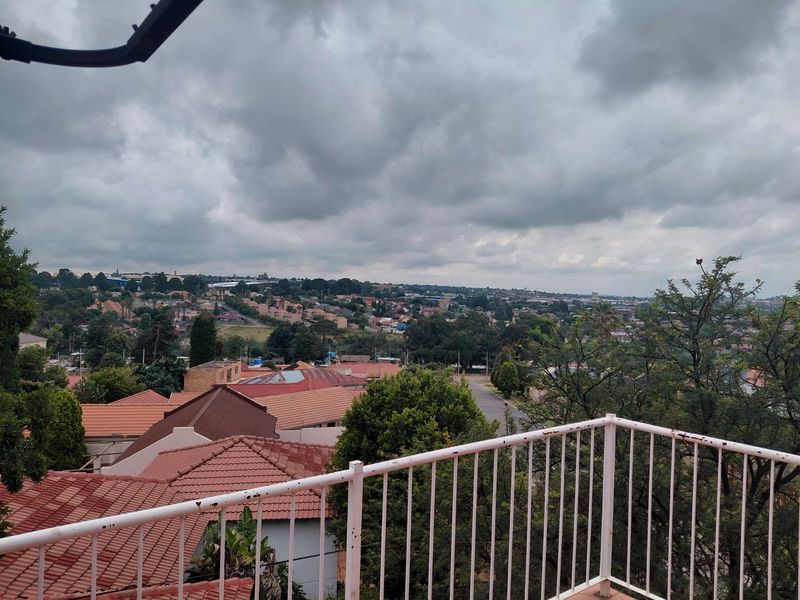 An elevated view overlooking the surrounding residential neighborhood, featuring a metal balcony railing in the foreground.