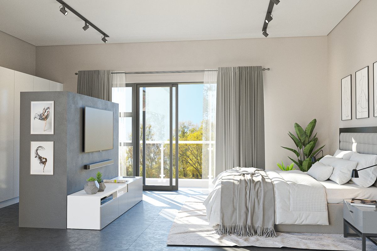 Modern bedroom featuring built-in wardrobes, track lighting, and a sliding glass door leading to a private balcony with scenic views.