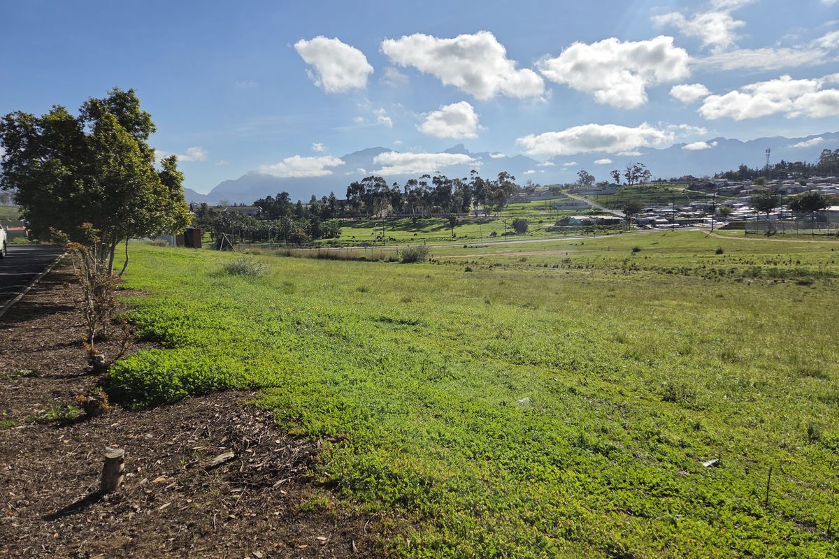 A scenic view of the vacant residential land featuring open green space with mountain vistas in the background.