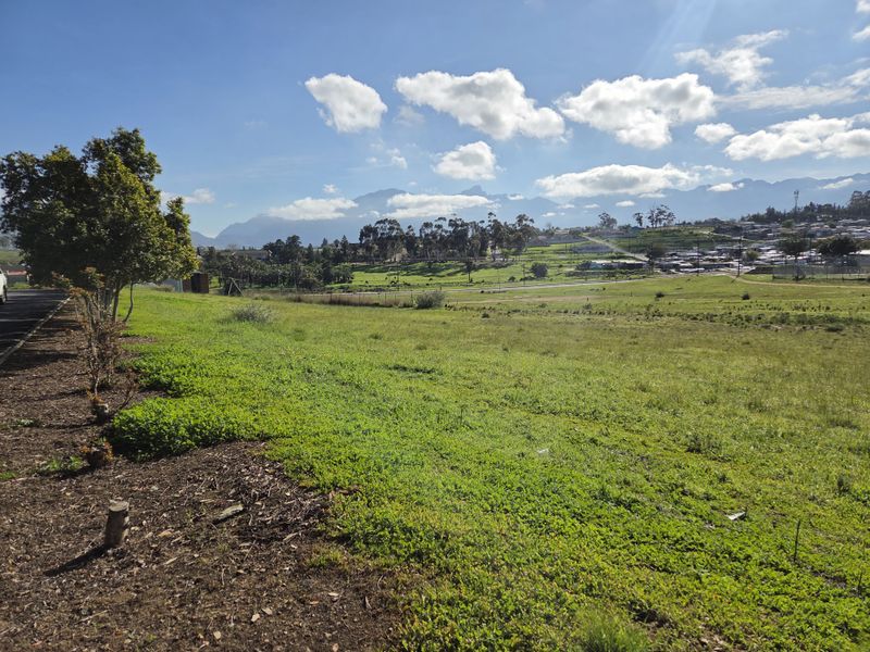 A scenic view of the vacant residential land featuring open green space with mountain vistas in the background.