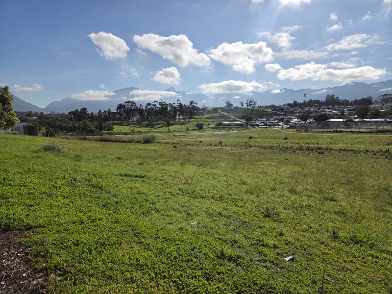 A scenic view of open grassland with a mountain range in the background, showcasing the natural landscape of the vacant residential land.
