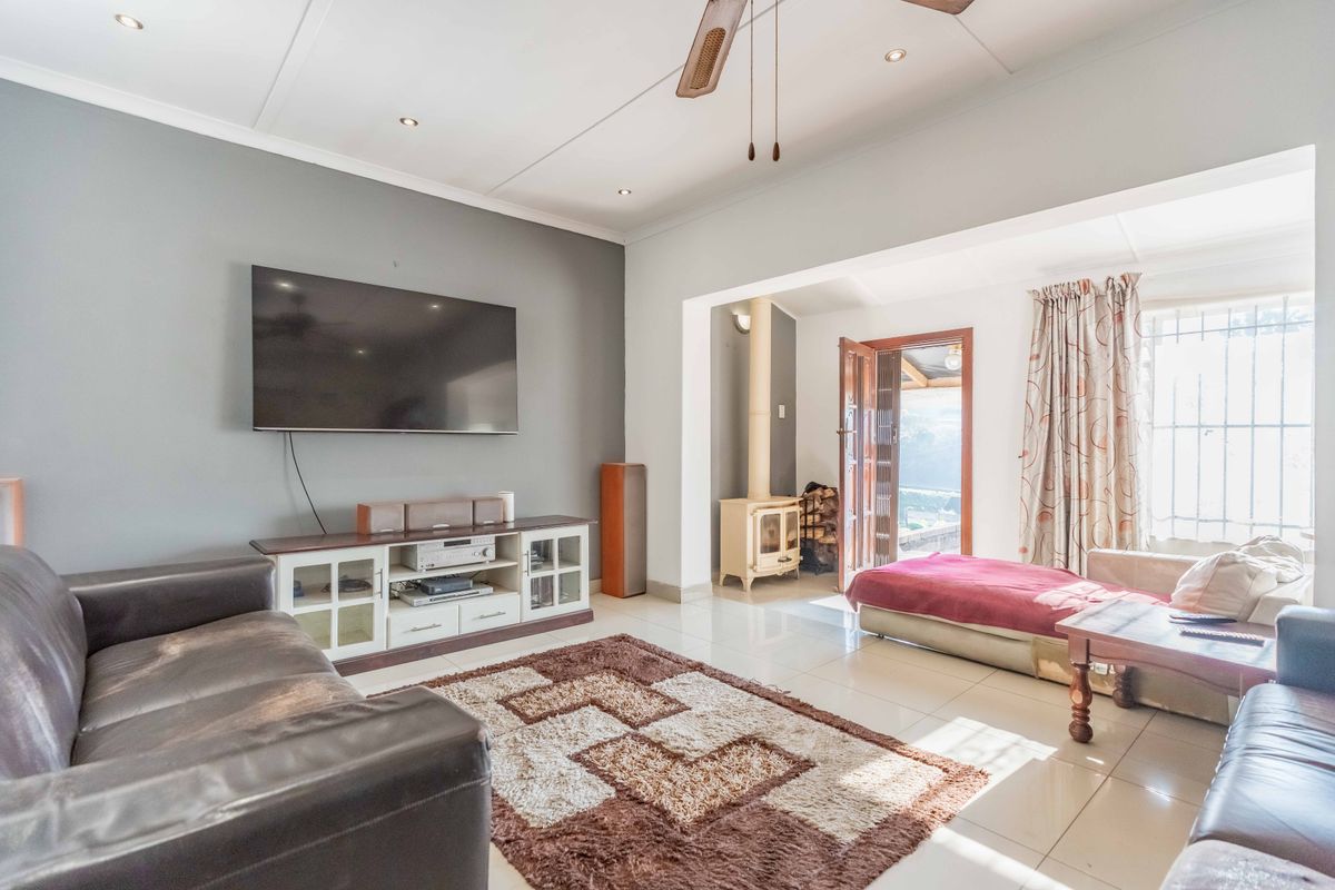 Spacious living room featuring tiled flooring, recessed lighting, and a cozy freestanding fireplace with direct access to the outdoor area.