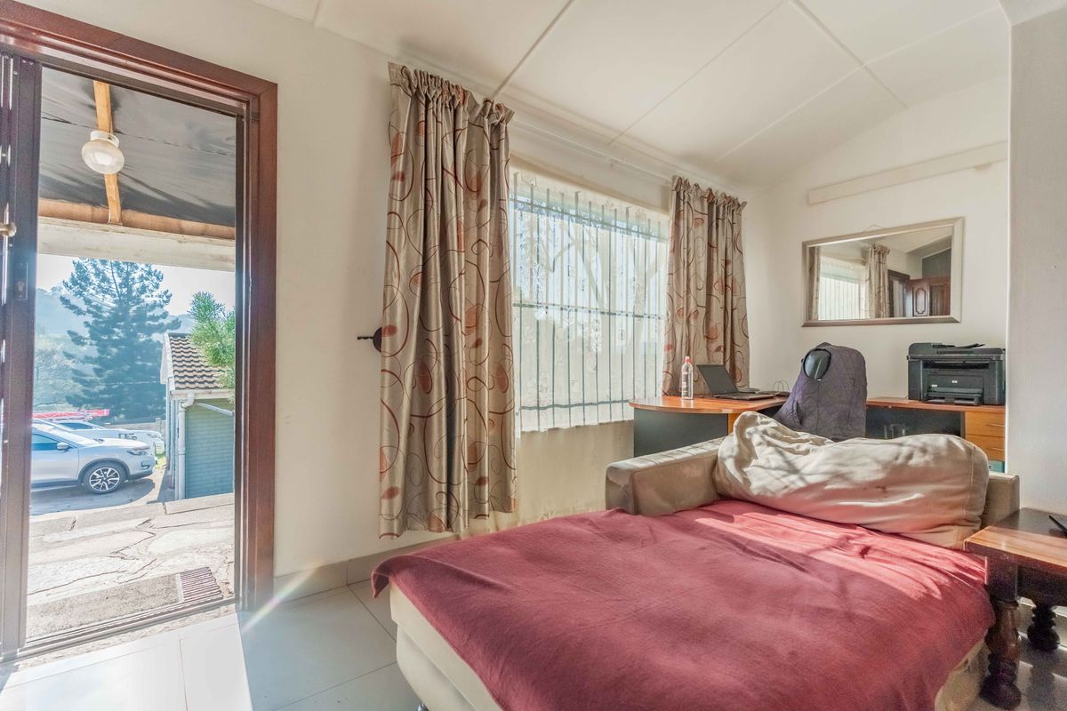 A bedroom featuring tiled flooring, a built-in mirror, and direct access to an outdoor area through an external door.