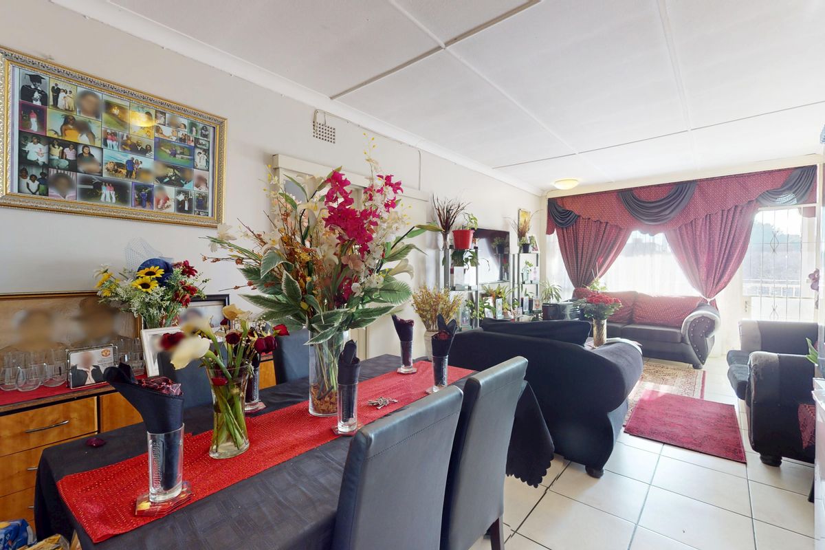 An open-plan living and dining area featuring tiled flooring and a standard ceiling, providing a functional space for daily living and entertaining.