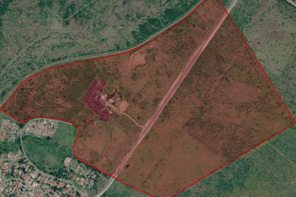 Aerial view of a large farm property with defined boundaries, internal access roads, and a cluster of farm buildings.