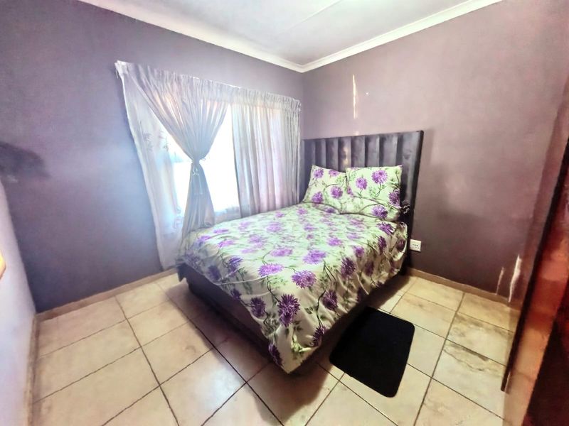 A compact bedroom featuring tiled flooring and coved ceilings, currently presented with a double bed.