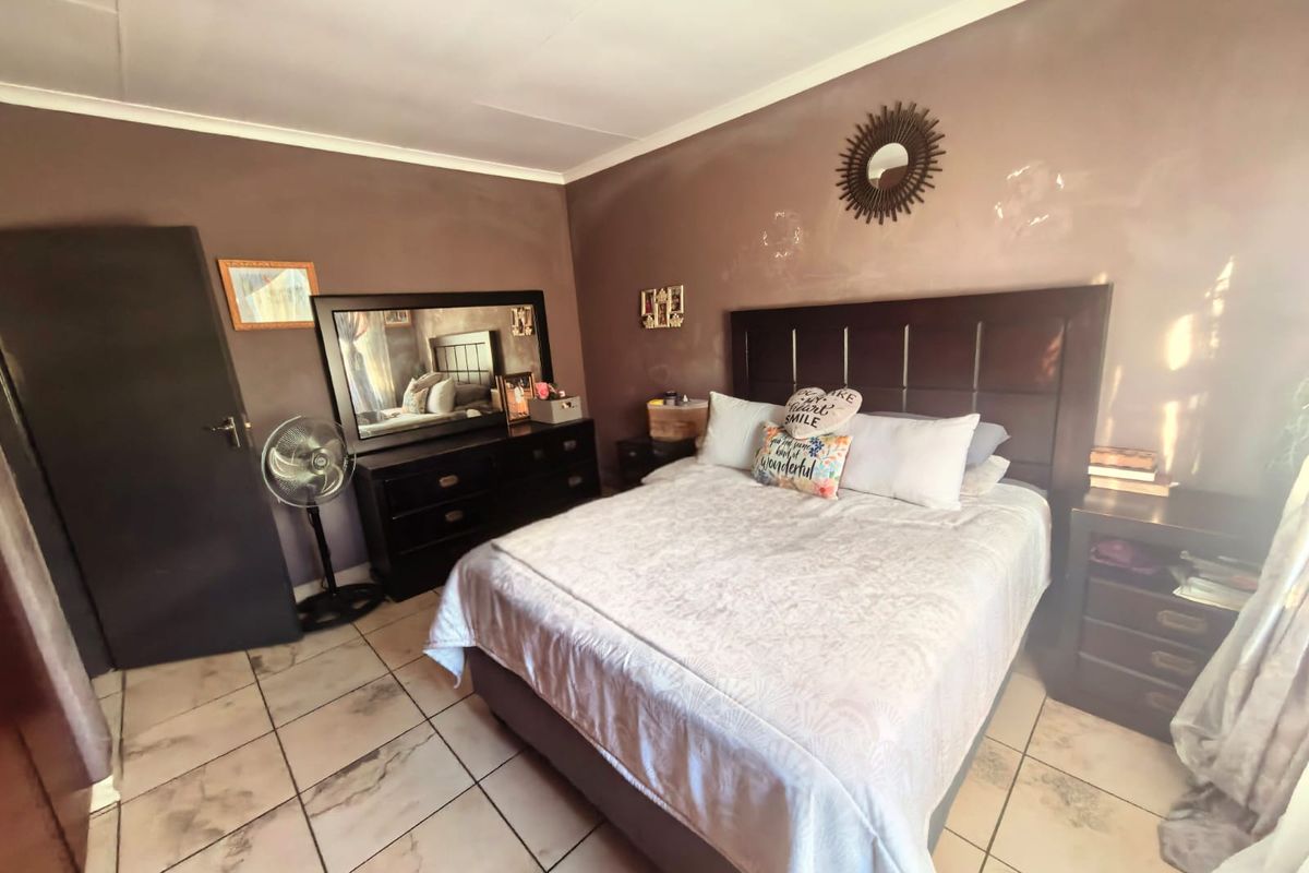 A bedroom featuring tiled flooring and dark-toned walls, providing a functional sleeping space with standard finishes.