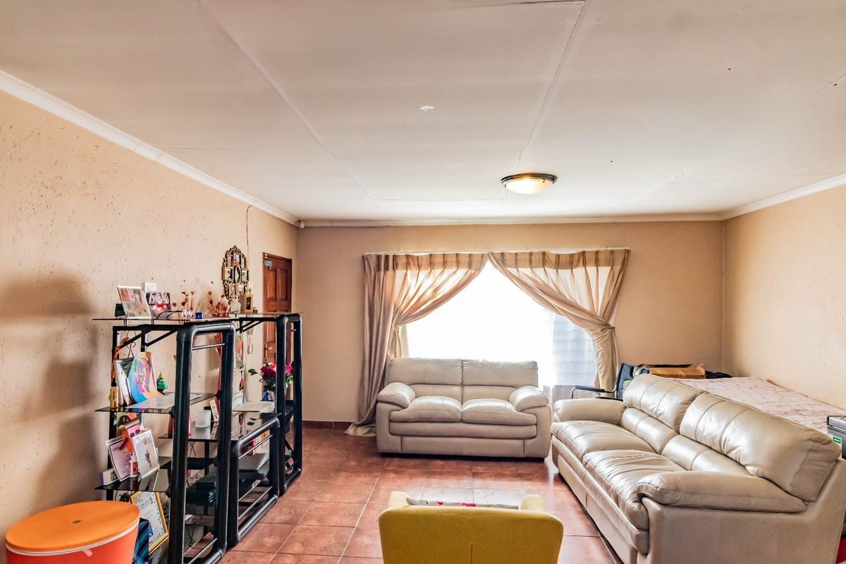 A living room featuring tiled flooring and a coved ceiling, requiring cosmetic updates to improve the overall aesthetic and finish.