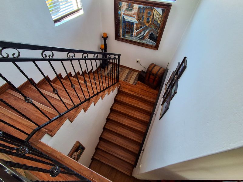 A well-maintained staircase featuring timber treads and a decorative wrought iron balustrade, providing a classic architectural transition between levels.