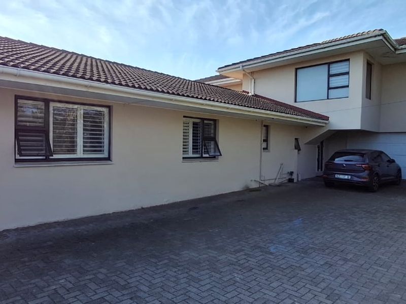 Front exterior view of the house featuring a paved driveway, tiled roof, and integrated garage access.