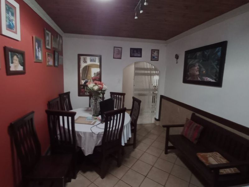 Dining room featuring tiled flooring, a timber ceiling, and an arched doorway leading to a secure entrance area.
