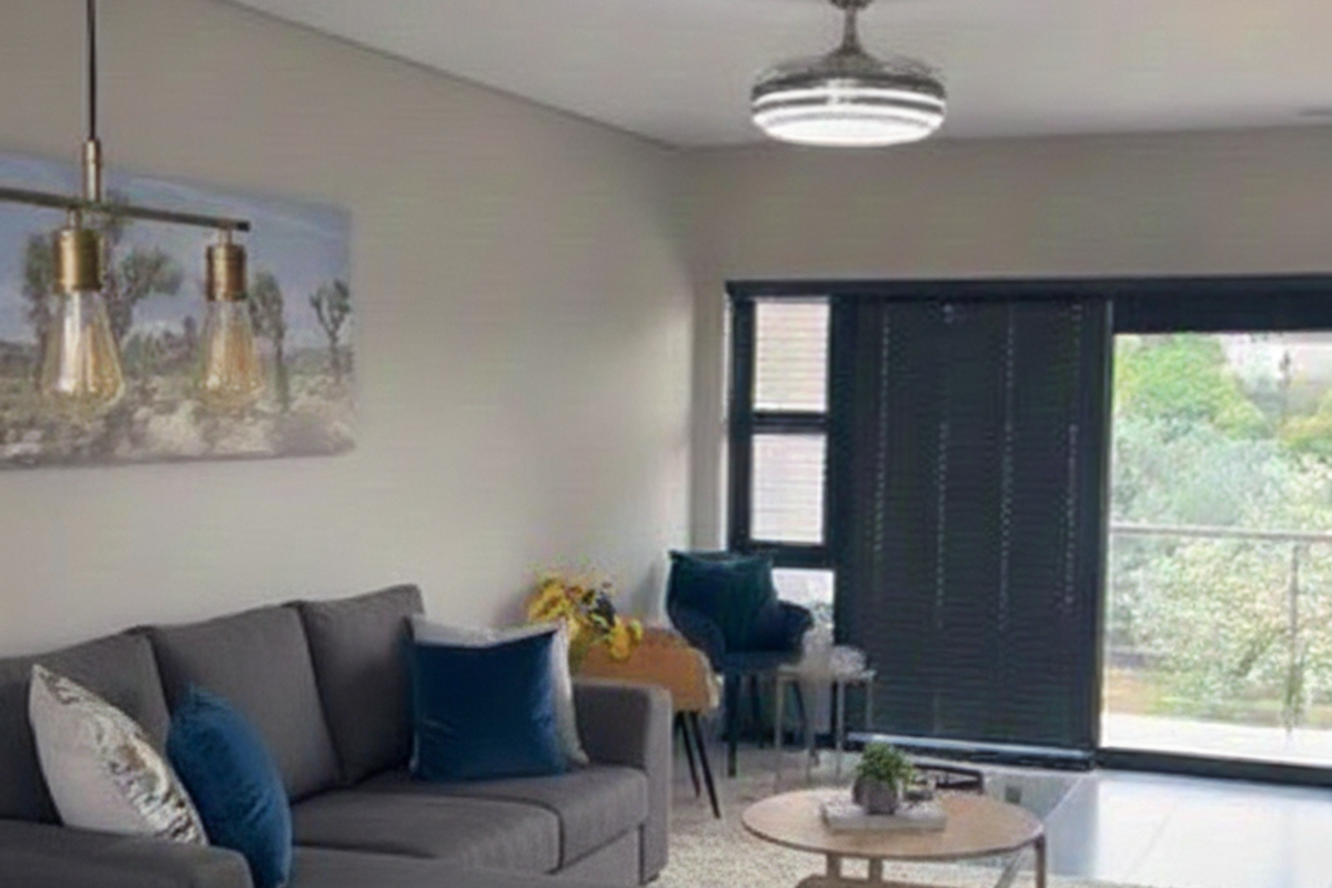 Modern open-plan living area featuring tiled floors, contemporary pendant lighting, a ceiling fan, and large sliding doors leading to an outdoor space.