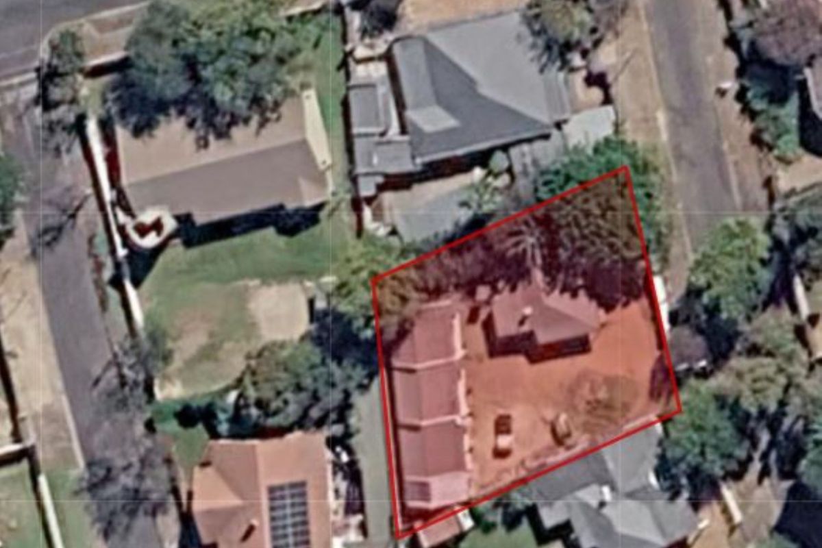 An aerial satellite view showing the property layout, roof structure, and surrounding residential plot boundaries.