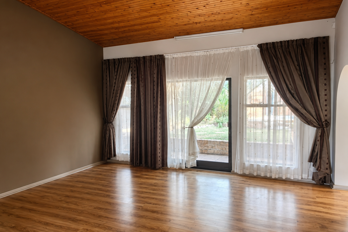 Spacious living room featuring laminate flooring, a timber-paneled ceiling, split-system air conditioning, and sliding glass doors providing access to the rear garden.