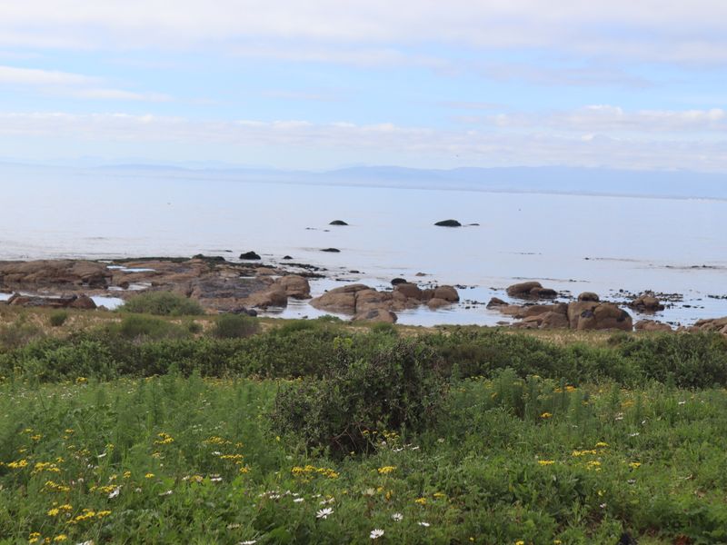 A scenic coastal view overlooking a rocky shoreline and the ocean, showcasing the natural landscape of the vacant residential property.