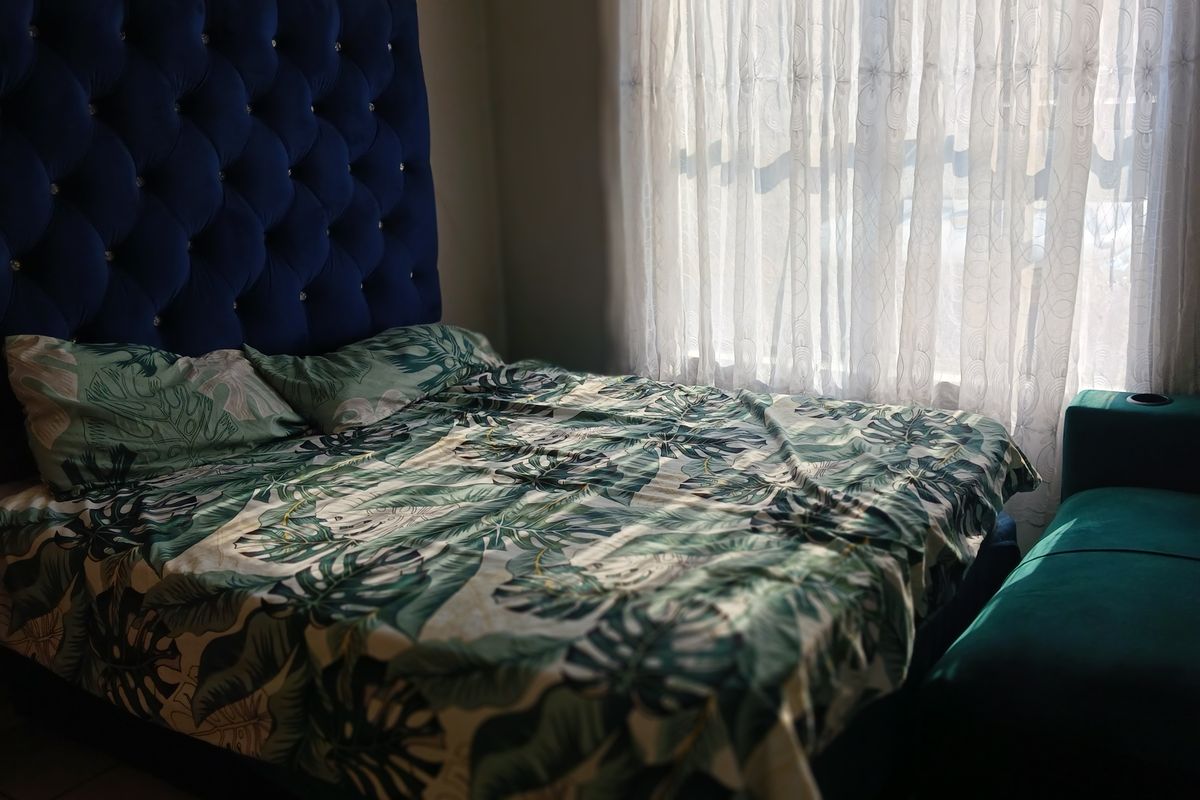 A bedroom featuring a window with sheer curtains, providing natural light to the space.