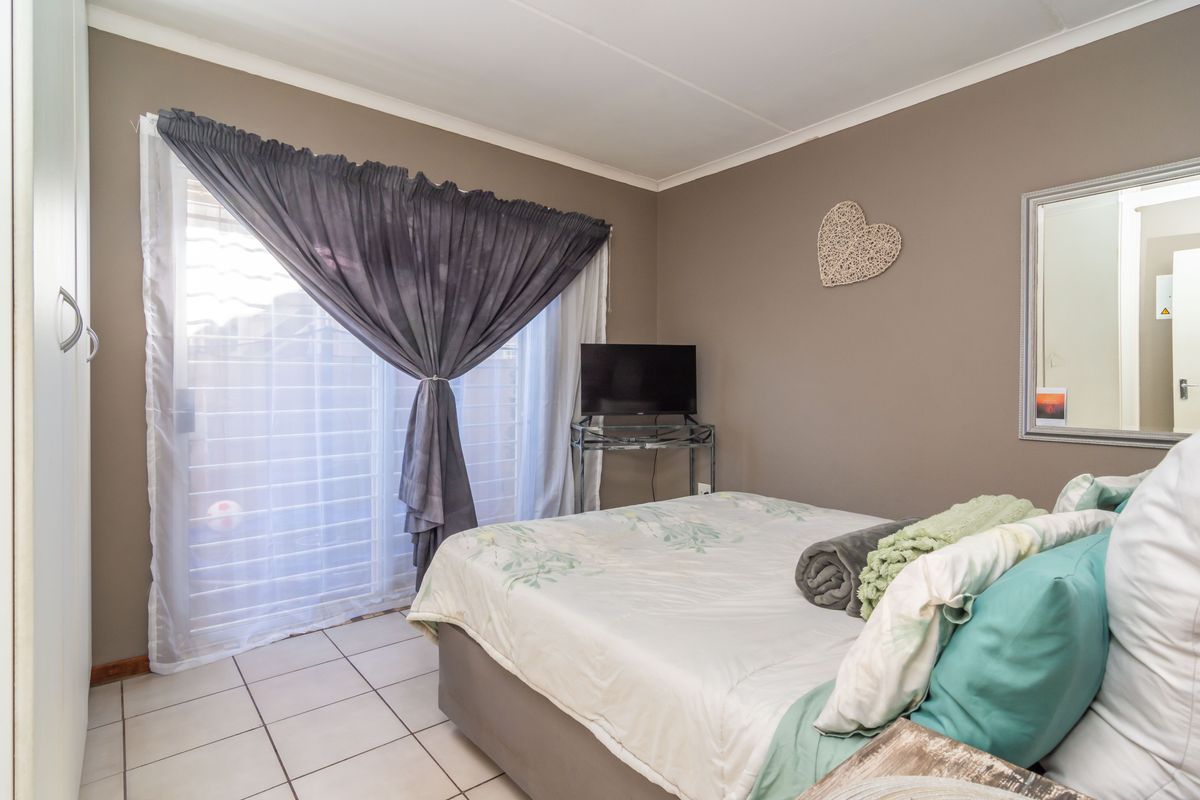 A bedroom featuring tiled flooring, a built-in wardrobe, and a sliding glass door providing access to the exterior.