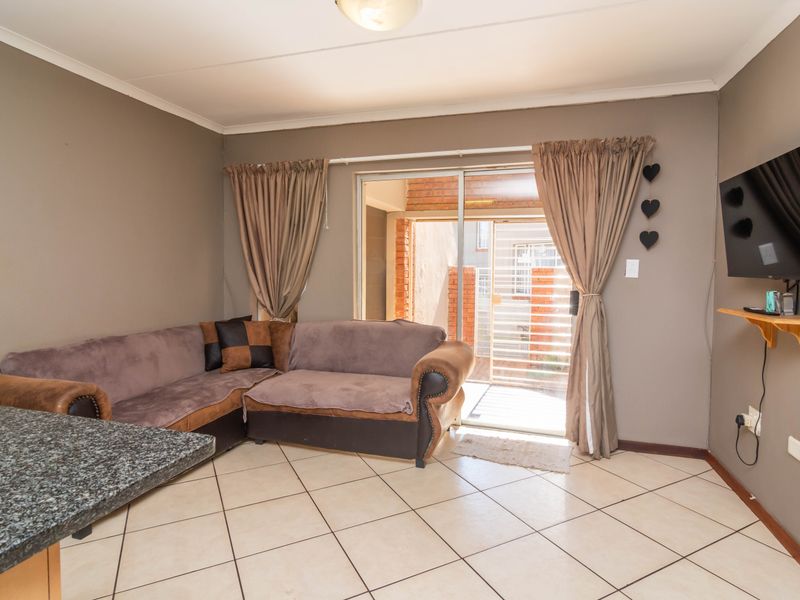 Open plan living area featuring tiled flooring, a granite breakfast bar, and sliding glass doors providing access to the exterior.