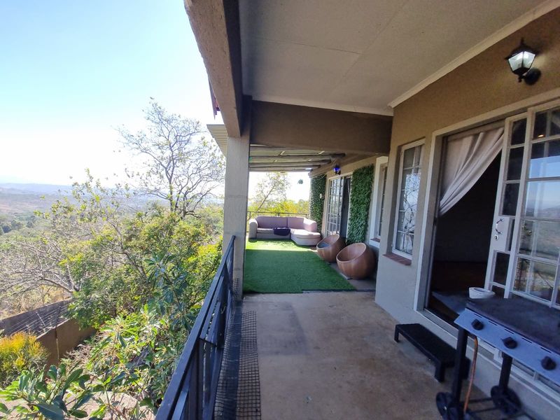 Covered balcony featuring a metal balustrade, concrete flooring, and direct access to the interior through sliding glass doors, offering scenic elevated views.