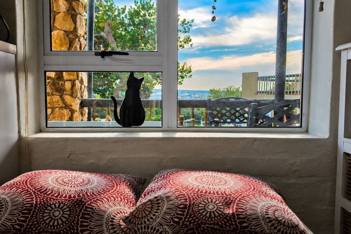 A cozy bedroom nook featuring a window with scenic outdoor views and rustic stone wall detailing.
