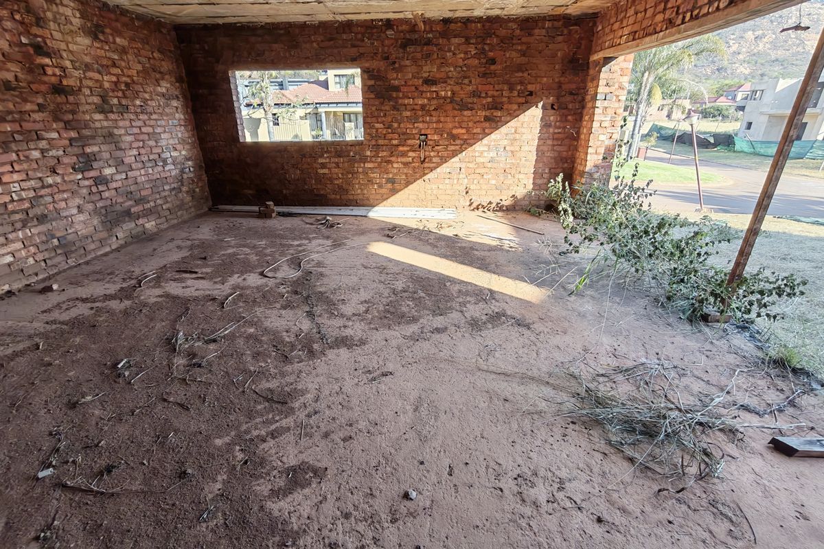 An unfinished interior space featuring exposed brick walls and a concrete ceiling, currently in a shell condition requiring full renovation and interior finishing.