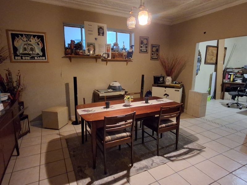 Dining room featuring tiled flooring and a ceiling light fixture, with visible wall cracks requiring maintenance.