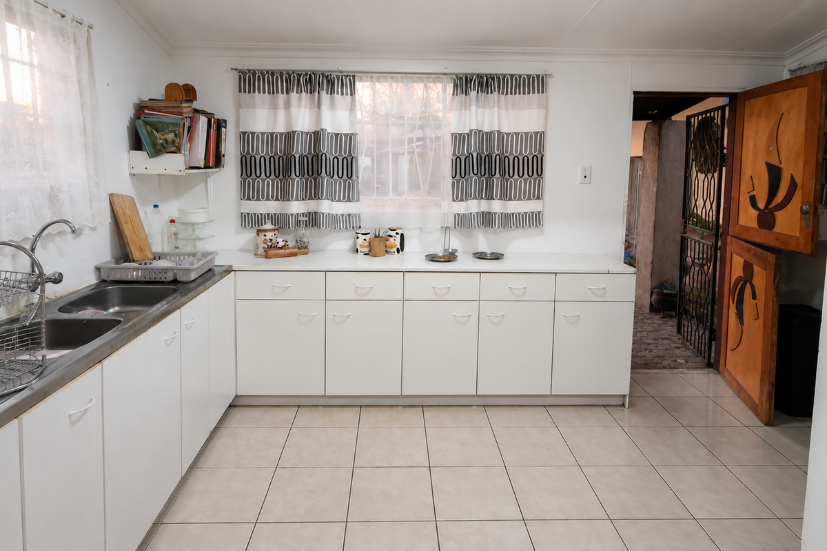 A functional kitchen featuring white cabinetry, laminate countertops, a double stainless steel sink, and ceramic floor tiles, with a unique wooden stable door.