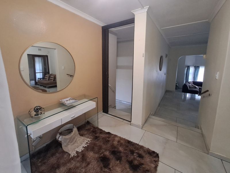 A welcoming entrance hall featuring tiled flooring and a staircase, providing a central access point to the home's living areas.