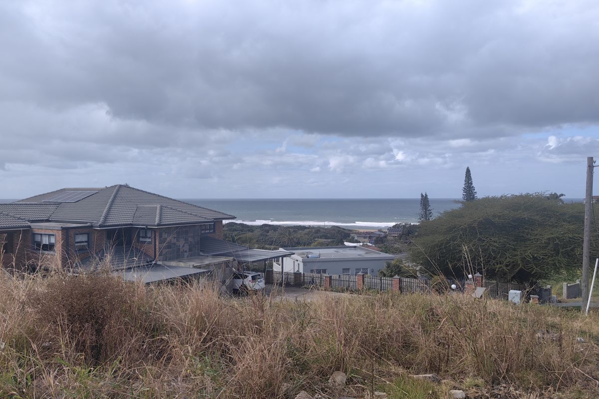 A scenic view overlooking the coastline and ocean from an elevated vacant residential plot.
