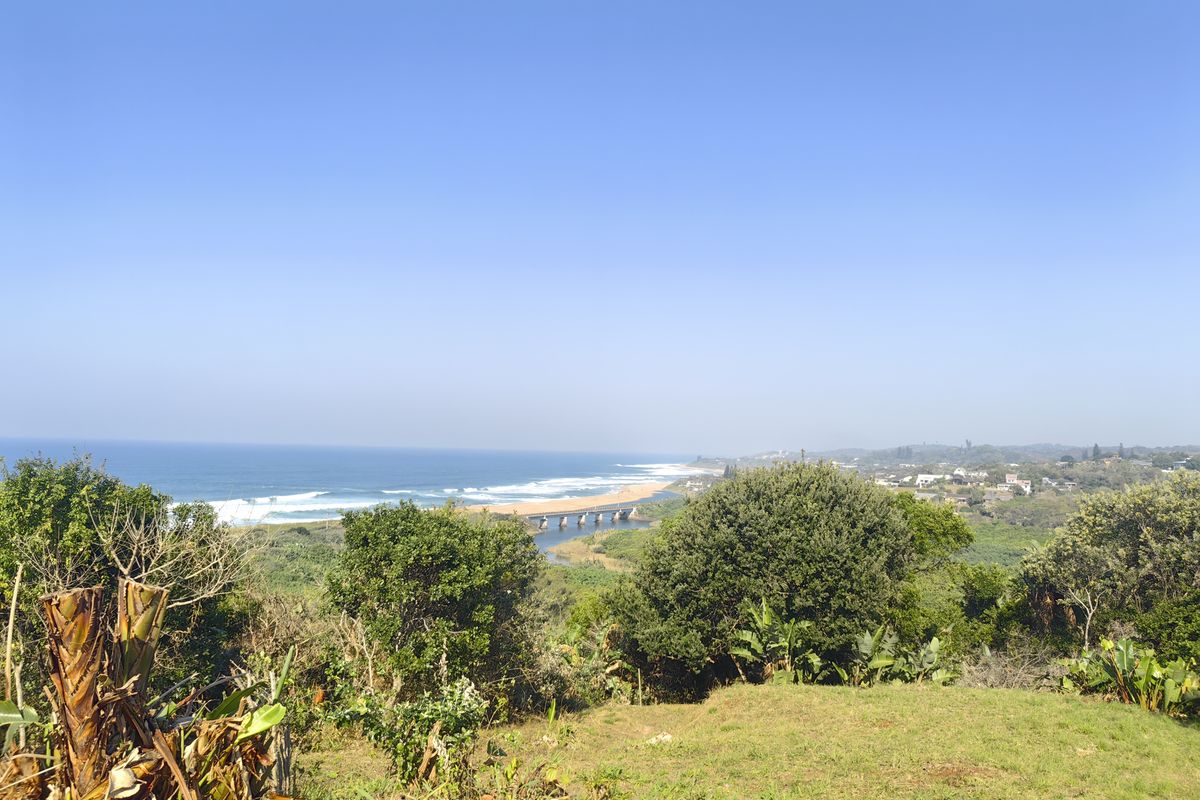 A scenic elevated view overlooking the coastline, ocean, and estuary, showcasing the natural landscape surrounding the property.