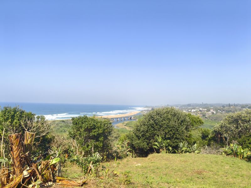 A scenic elevated view overlooking the coastline, ocean, and estuary, showcasing the natural landscape surrounding the property.