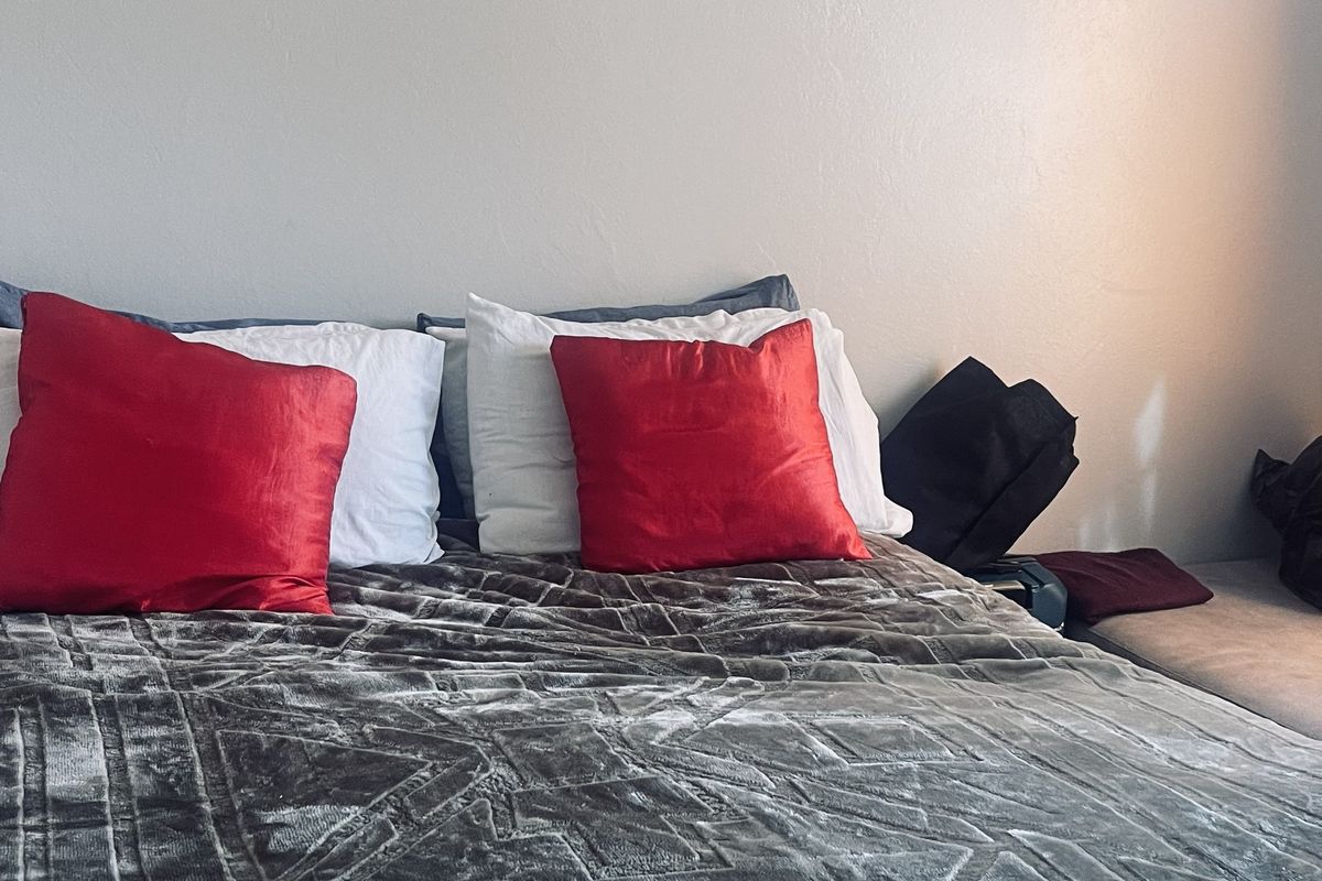 A bedroom interior featuring a bed against a plain wall, providing a simple and functional sleeping space.