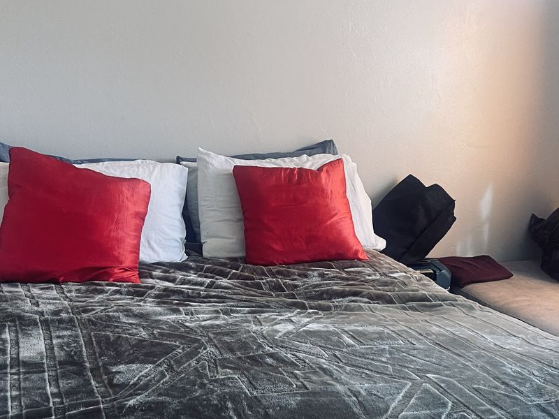 A bedroom interior featuring a bed against a plain wall, providing a simple and functional sleeping space.