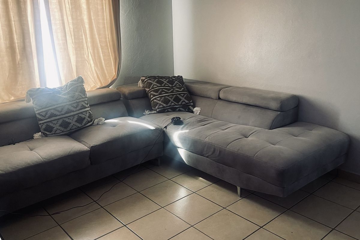 A living room area featuring tiled flooring and natural light from the window.