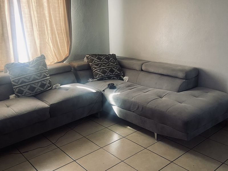 A living room area featuring tiled flooring and natural light from the window.