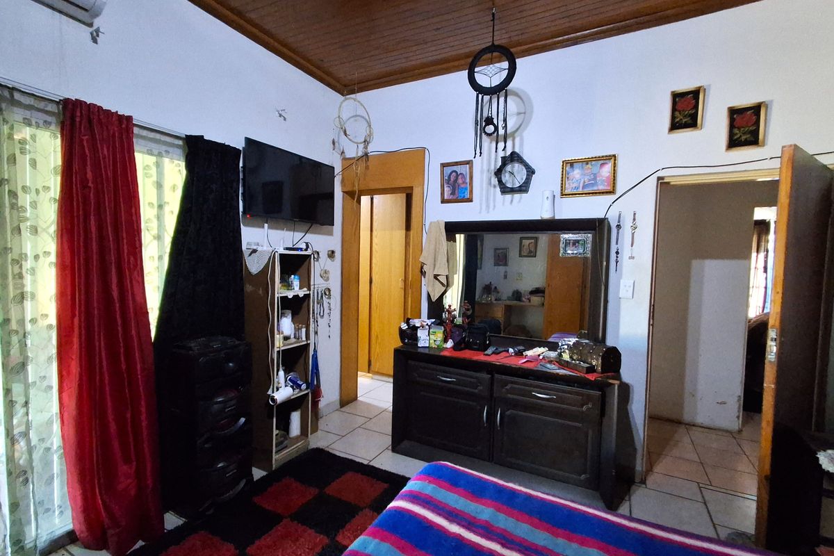 A bedroom featuring tiled flooring, a timber ceiling, and a sliding glass door providing access to the exterior.