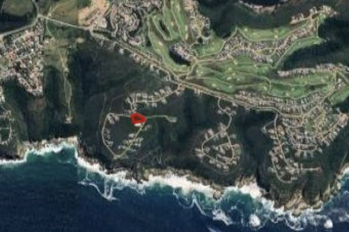 An aerial view of the coastal residential estate, highlighting the location of the vacant land plot within the surrounding landscape.