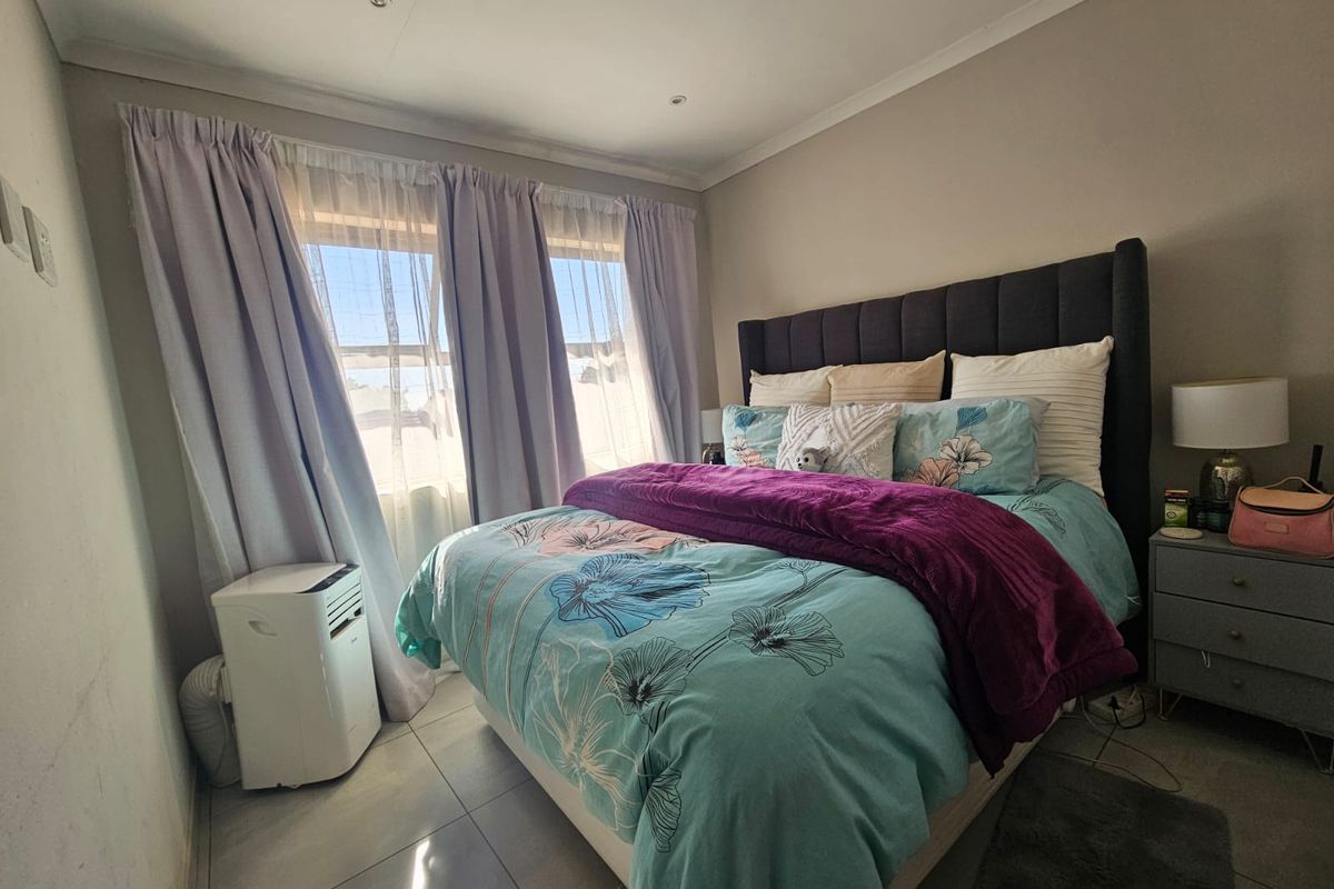 A well-lit bedroom featuring tiled flooring and recessed downlights, providing a functional and comfortable sleeping space.