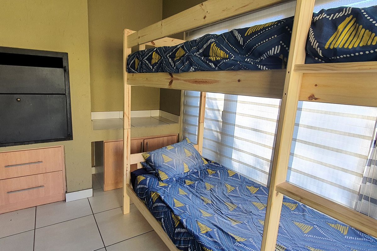 Bedroom featuring tiled flooring, built-in cabinetry, and a built-in indoor braai unit, offering a functional and versatile living space.