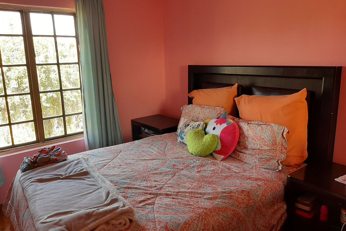 A bedroom featuring a multi-pane window with natural light and painted walls.