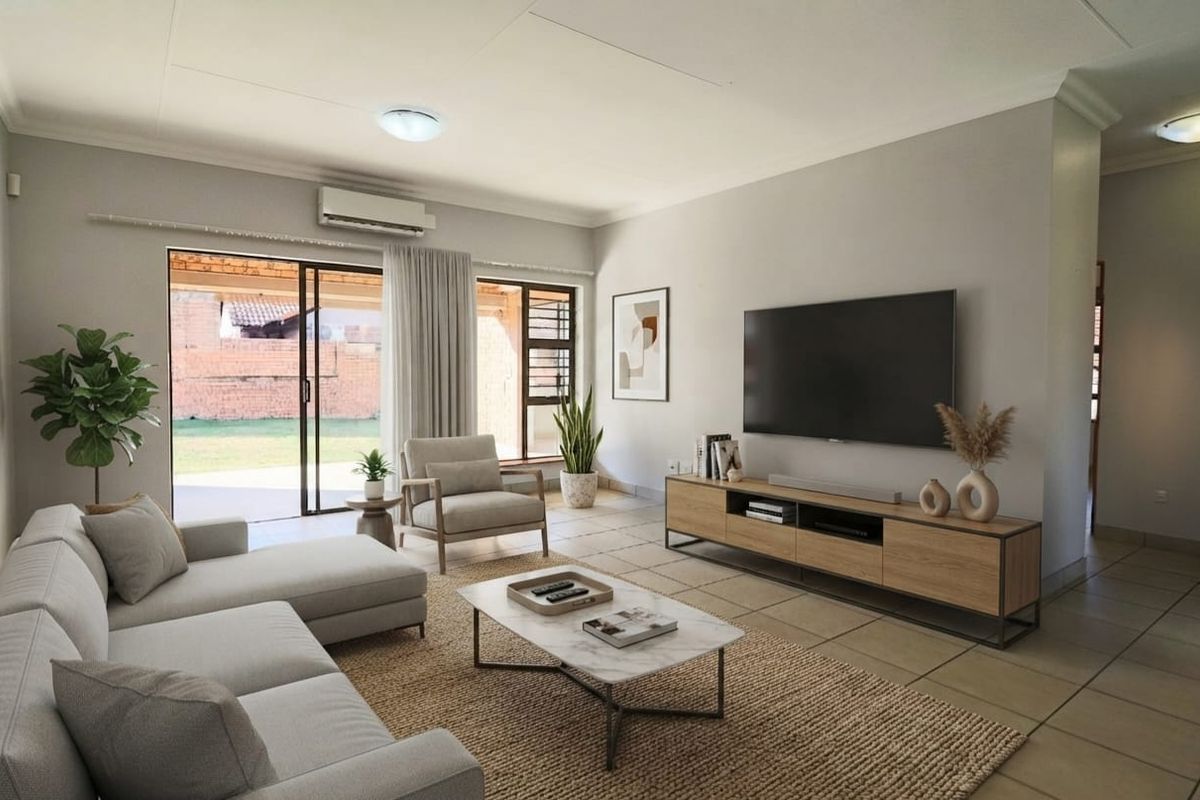 A bright and well-maintained living room featuring tiled flooring, a split-system air conditioner, and large sliding glass doors providing access to the patio.
