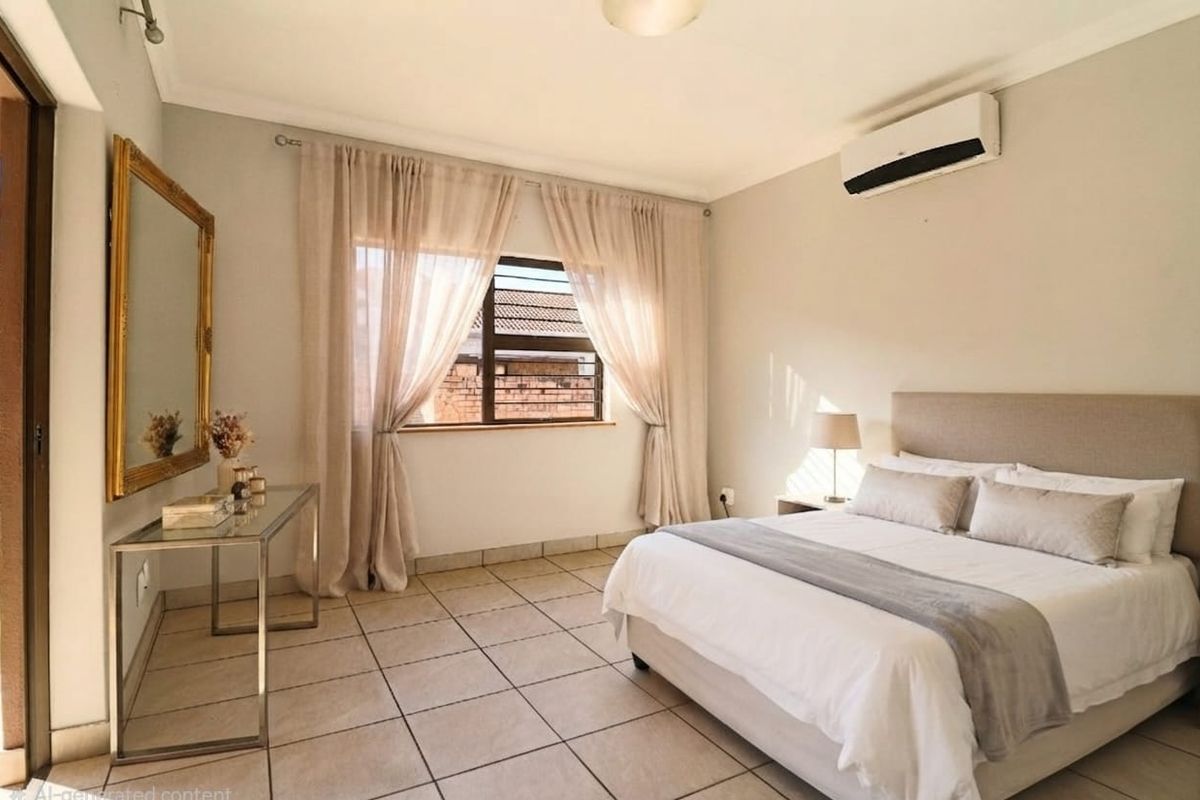 A well-lit bedroom featuring neutral tiled flooring, a wall-mounted split-system air conditioner, and large windows with security bars.