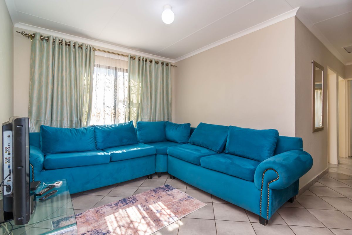 A living room featuring tiled flooring and coved ceilings, providing a functional and neutral space for relaxation.
