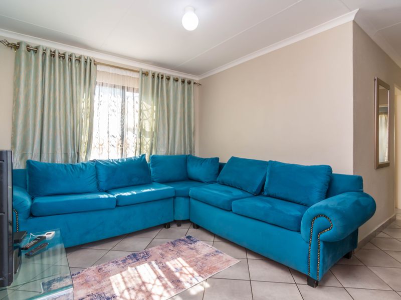 A living room featuring tiled flooring and coved ceilings, providing a functional and neutral space for relaxation.
