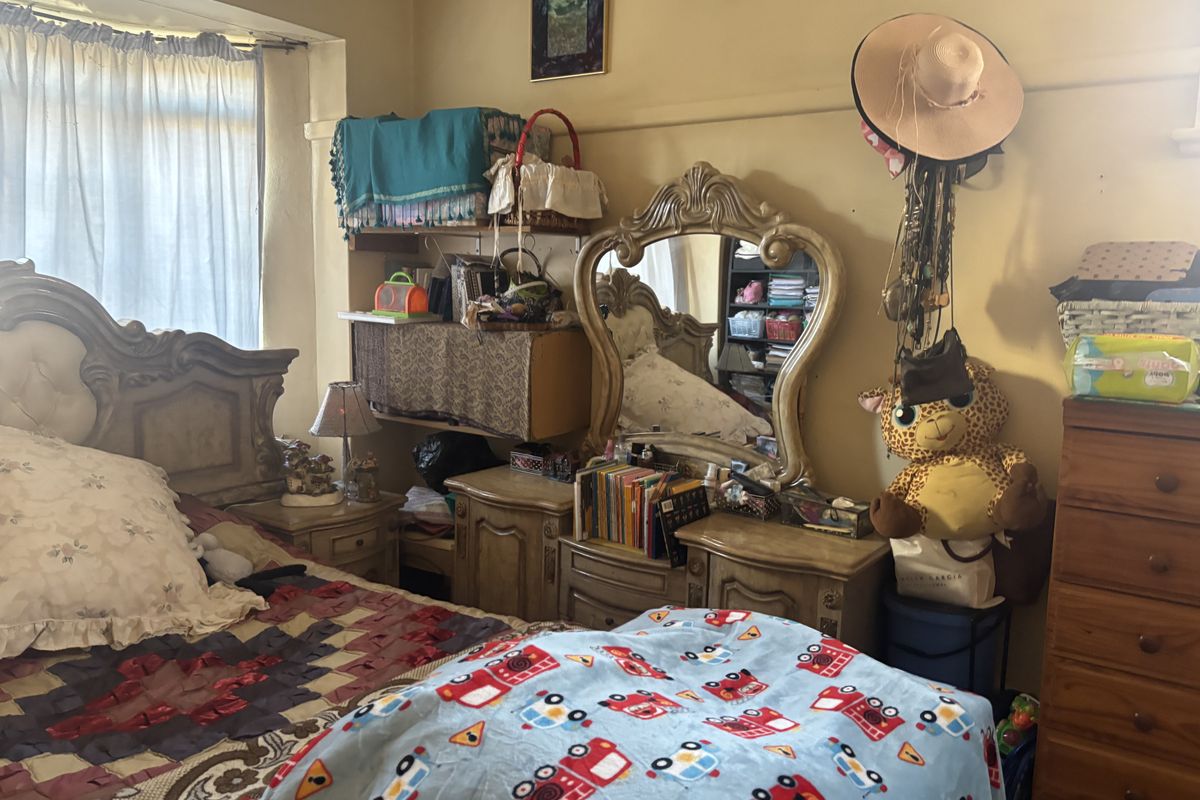 A bedroom featuring a picture rail and window with natural light, currently furnished with a bed and vanity unit.