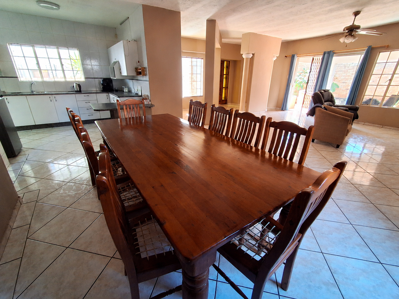 Open-plan kitchen and dining area featuring tiled flooring, built-in cabinetry, and direct access to the outdoor patio through sliding glass doors.