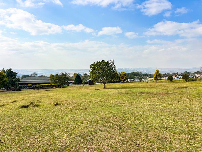 A wide-angle view of the expansive, well-maintained grassy grounds and surrounding landscape, showcasing the property's open outdoor space.